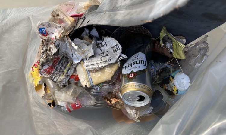 Blick in einen Müllsack mit gesammeltem Müll von der Strasse